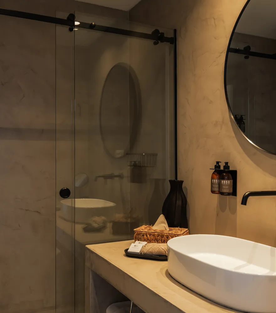 Bathroom with round mirror and stone basin