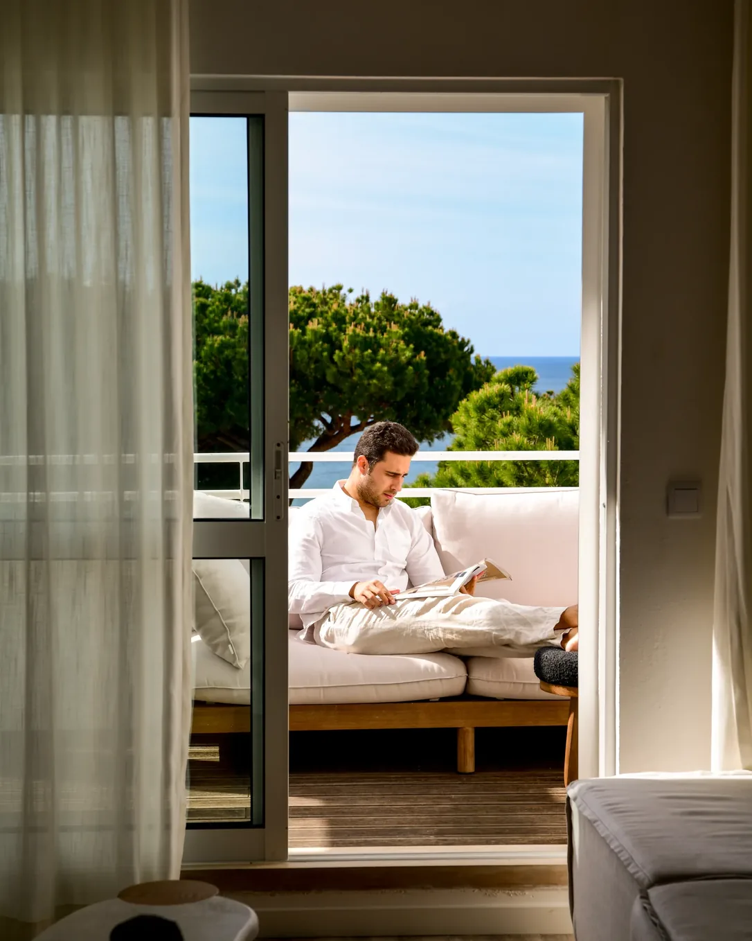 A guest reading on the terrace of an apartment at Masana