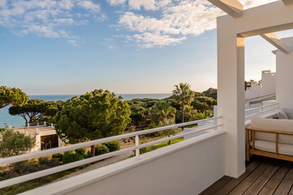 A balcony over the pines to the sea, late in a winter afternoon